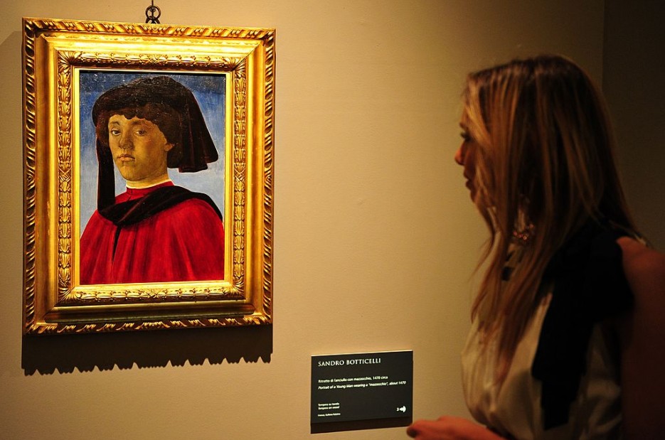 A visitor looks at a portrait of Sandro Botticelli